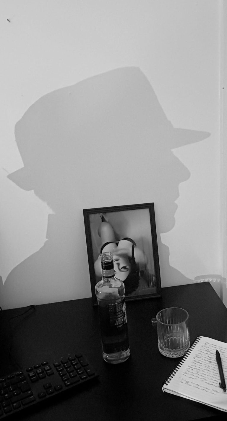 Desk with photo of beautiful woman, wedding ring and whiskly.